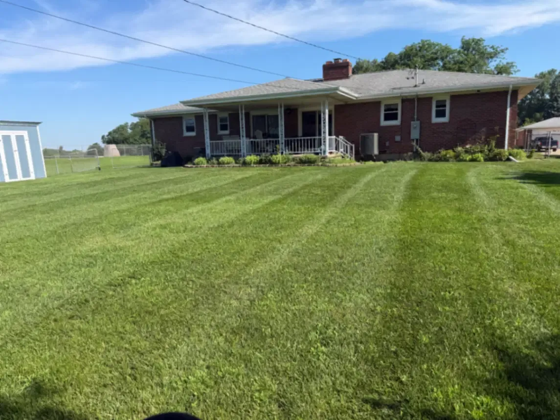 Residential lawn service with mowing stripe lines at a brick ranch in Fulton, Illinois
