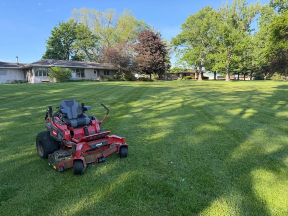 Residential lawn mowing service with a red Toro zero-turn mower in Fulton, Illinois and Clinton, Iowa